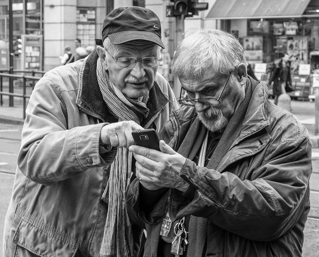 two men looking at a mobile phone
